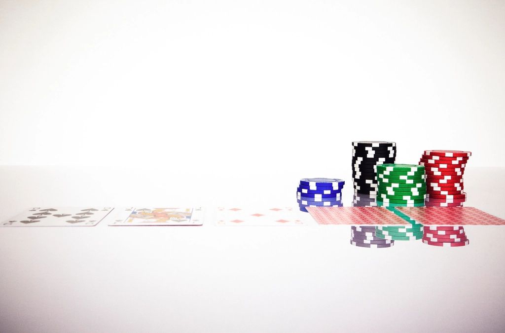 Tumpukan keping poker dan kartu remi di meja